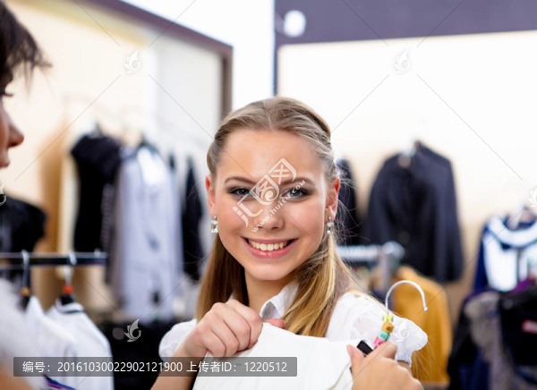 年輕的女人在一家商店買衣服