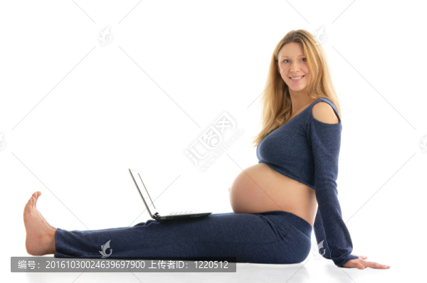 孕婦與筆記本電腦坐在地板上