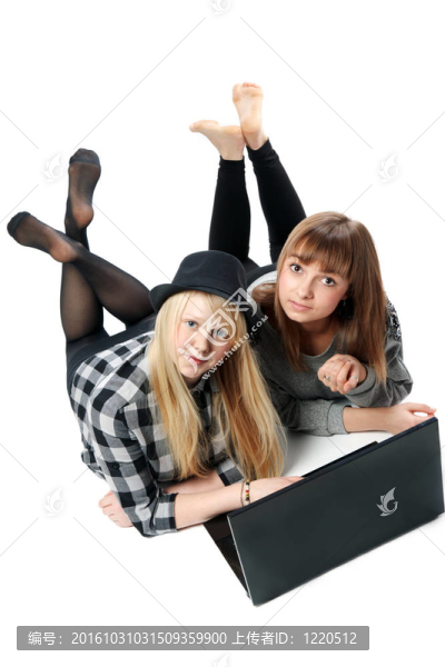 兩個(gè)女孩躺在電腦上