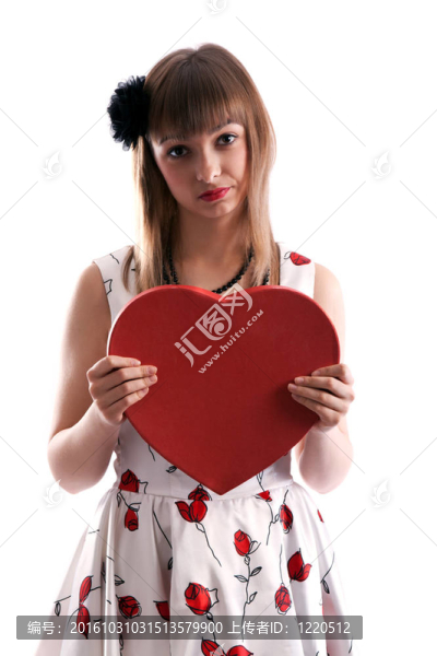 美麗的女孩穿著紅色的衣服和心在手