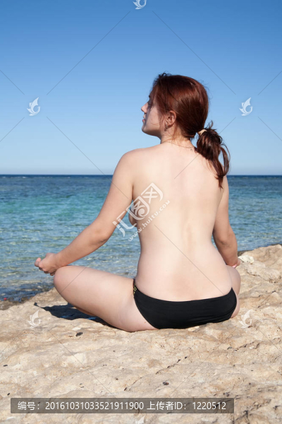 在海邊做瑜伽的年輕女孩