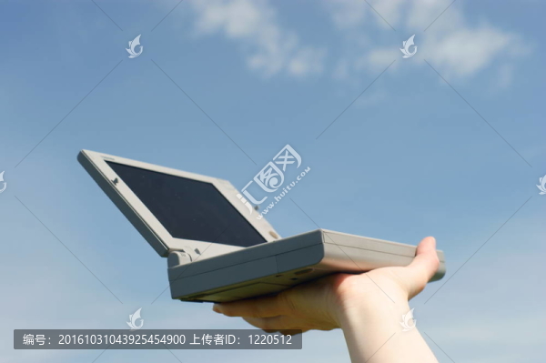 筆記本電腦在一個(gè)藍(lán)色的天空在女人手。