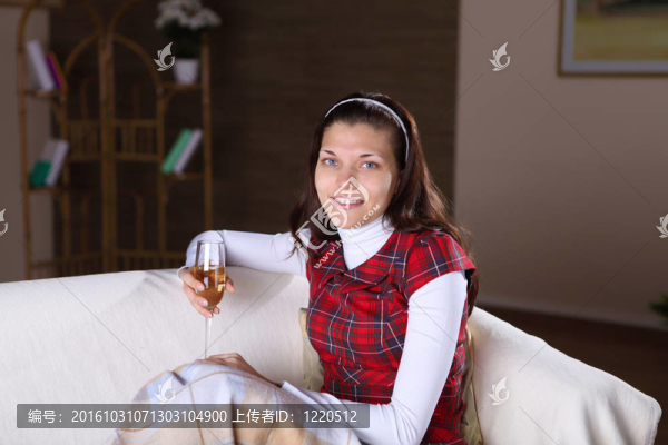 一個(gè)女孩在家里喝了一杯酒