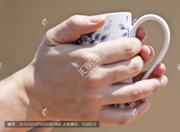手拿著杯子喝