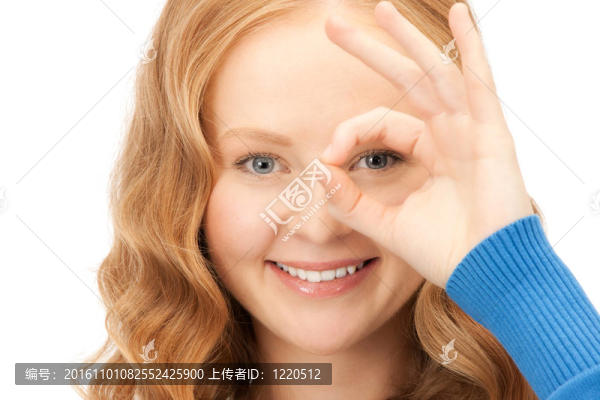 可愛的女人透過手指看洞
