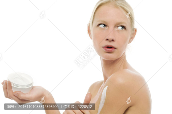 一個(gè)年輕白人婦女在身體上涂保濕乳液的肖像