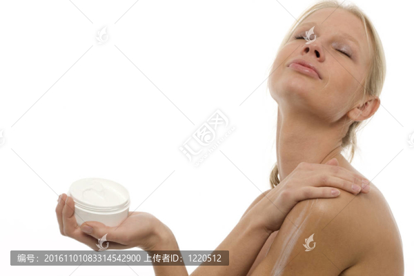 一個(gè)年輕白人婦女在身體上涂保濕乳液的肖像