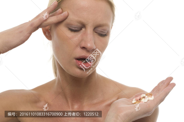 一個(gè)用手中的偏頭痛的年輕白人婦女肖像丸劑