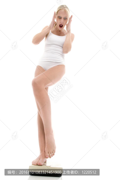年輕的白人婦女穿著內(nèi)衣站在磅秤和恐懼