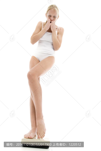 年輕的白人婦女穿著內(nèi)衣站在磅秤和恐懼