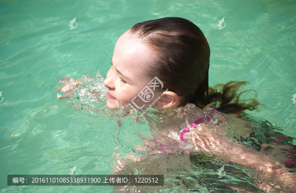 在夏日的炎熱中游泳的少女。