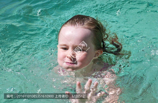 在夏日的炎熱中游泳的少女。