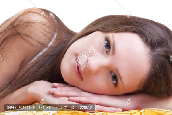 年輕女子躺在彩色枕頭，看著你