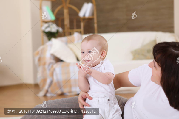 一位年輕的母親帶著她的嬰兒在家