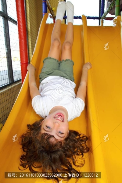 小女孩在操場上笑滑梯