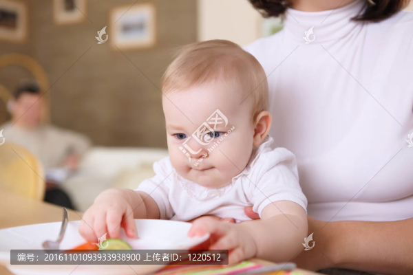 一個年輕的母親在家里喂她的嬰兒