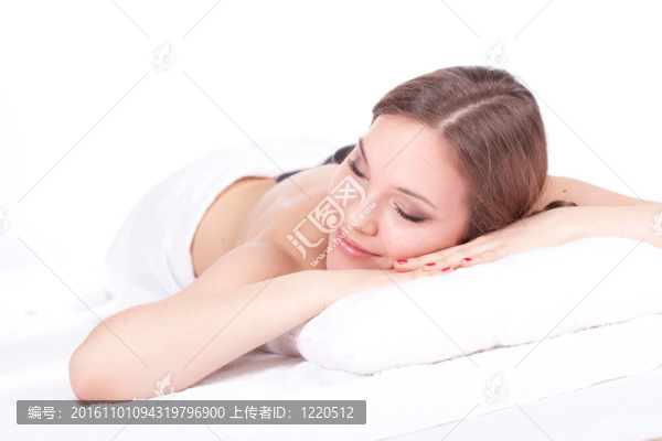 美麗的年輕女子在水療院；石頭按摩