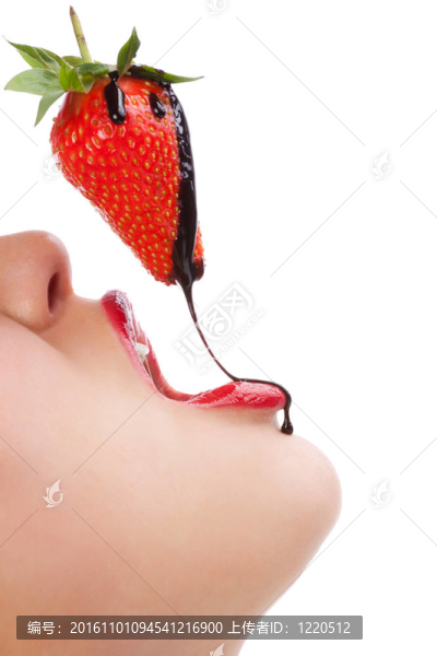 女孩用巧克力沙司吃草莓