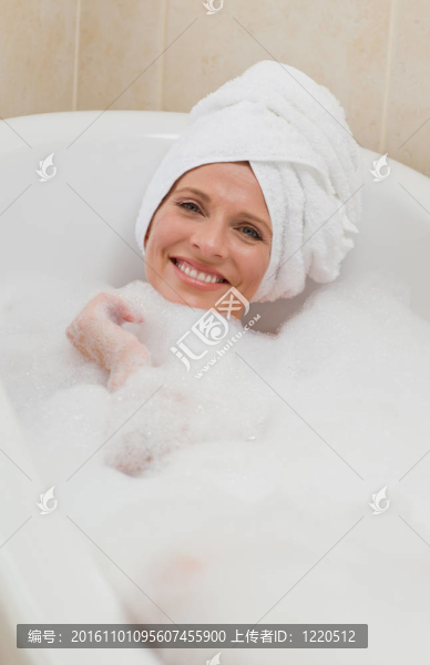 可愛的女人用毛巾在頭上洗澡
