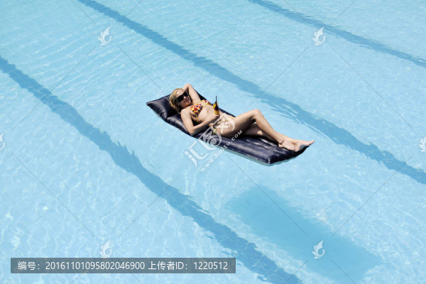 美麗的女人在游泳池放松