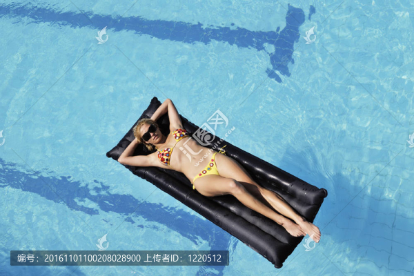 美麗的女人在游泳池放松