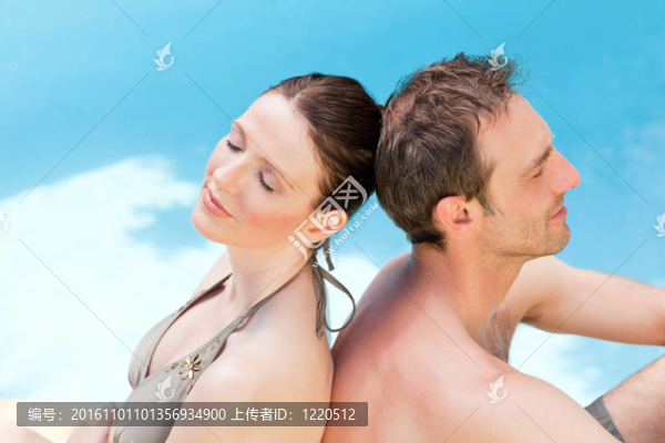 夫婦坐在游泳池后面回到