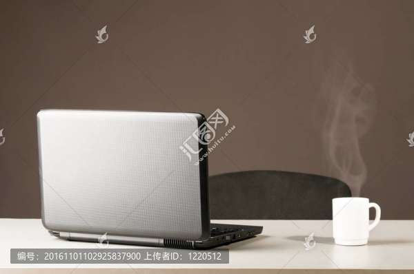 帶有白色杯子的筆記本電腦
