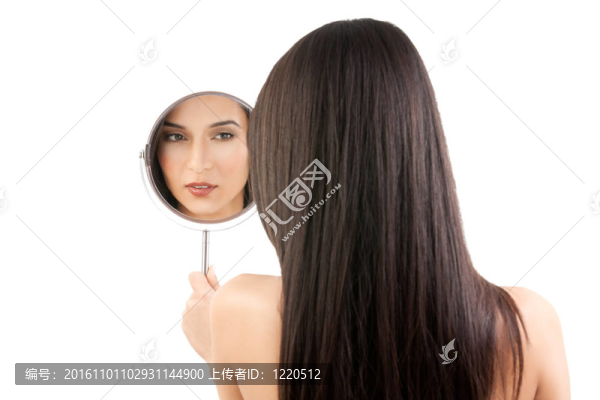 一個年輕女子看鏡子的美麗形象。
