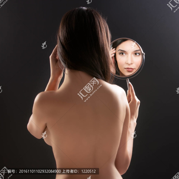 一個美麗的工作室的照片，一個年輕女子在鏡子里，而她的背轉(zhuǎn)向相機。鏡子放在她的左肩上，折射出她笑容。