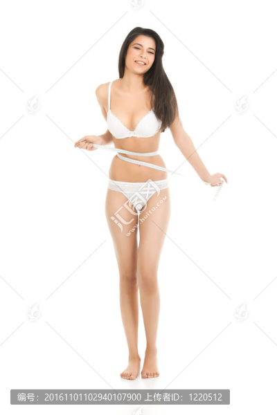 一個年輕漂亮女人的工作室；測量她的腰圍。她穿著內(nèi)衣，她試圖從計量表中得到一個較小的數(shù)字.。
