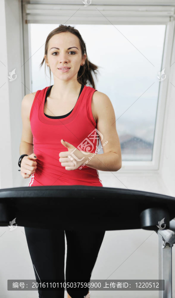 在健身俱樂部womanworkout在軌道上運(yùn)行的機(jī)器