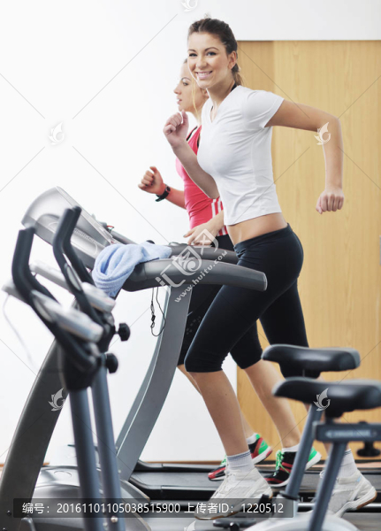 在健身俱樂部womanworkout在軌道上運行的機器