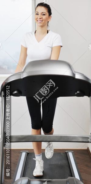 在健身俱樂部womanworkout在軌道上運(yùn)行的機(jī)器