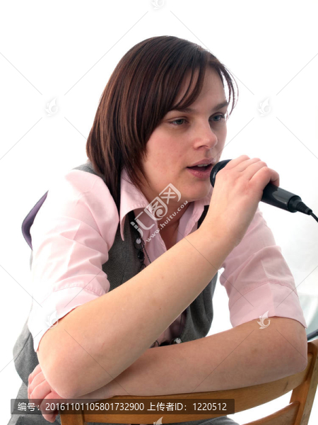 年輕的女人對著麥克風唱歌