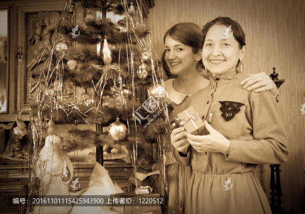 舊貨照片的女兒與母親裝飾圣誕樹在家里