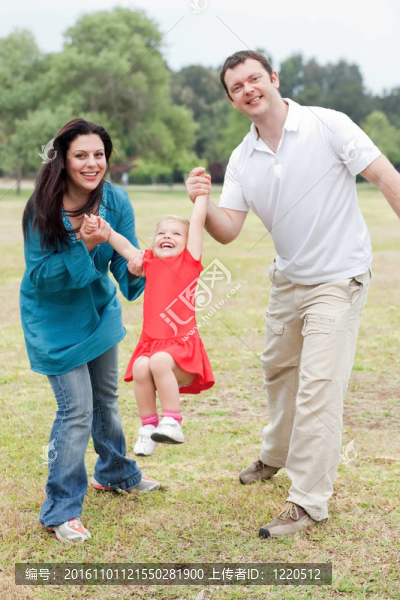可愛的夫婦在公園里玩他們快樂的女兒
