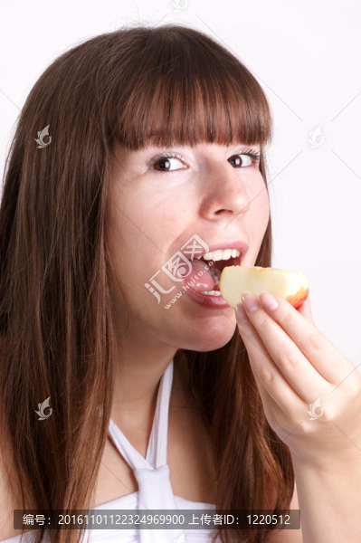 一個(gè)年輕的女人吃一個(gè)有機(jī)蘋(píng)果