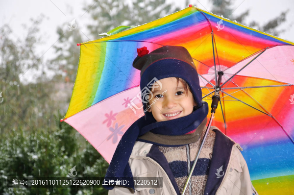 帶著雨傘站在雨中的男孩