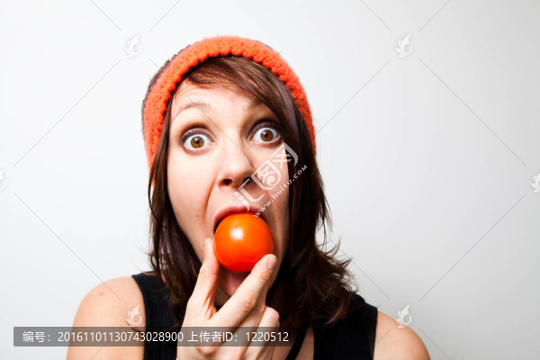 年輕的女人吃西紅柿