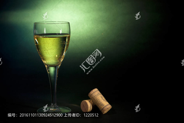 飲料藝術。一杯白葡萄酒；黑綠色的背景