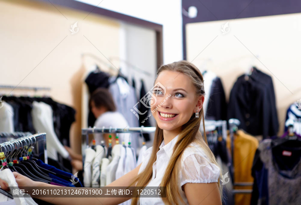 年輕的女人在一家商店買衣服