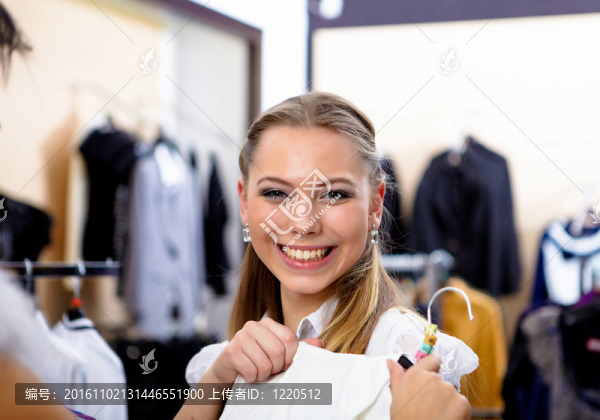 年輕的女人在一家商店買衣服