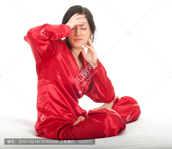 遭受痛苦-年輕女子穿著紅色睡衣頭痛，手近臉