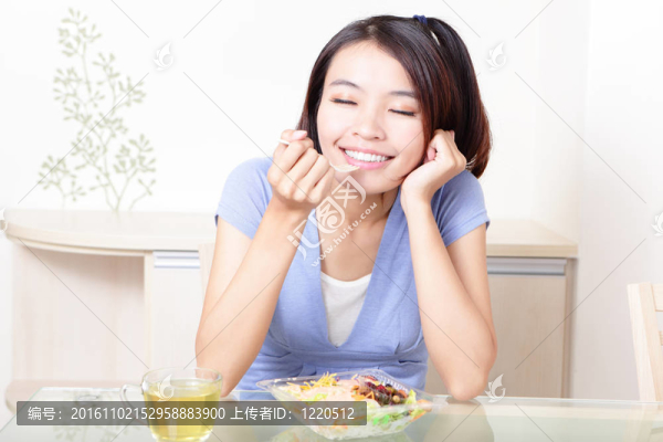 幸福的微笑的女人在家里沙拉