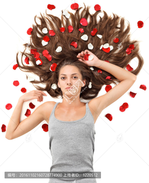 年輕漂亮的黑發(fā)女人散亂的長(zhǎng)頭發(fā)和白色玫瑰的花瓣上