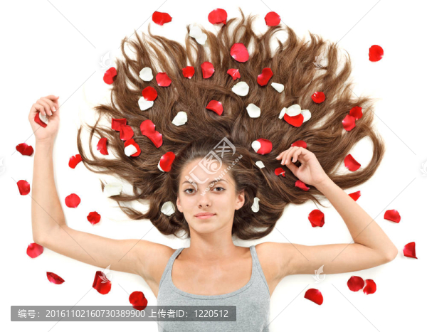 年輕漂亮的黑發(fā)女人散亂的長(zhǎng)頭發(fā)和白色玫瑰的花瓣上