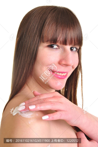 年輕的女人穿上一些保濕霜