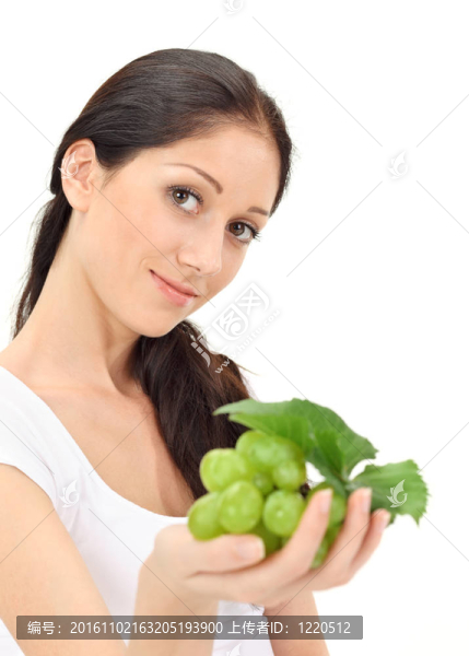 年輕迷人的女人與綠色葡萄簇