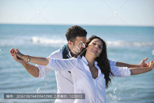 快樂的年輕夫婦在美麗的海灘上玩得開心