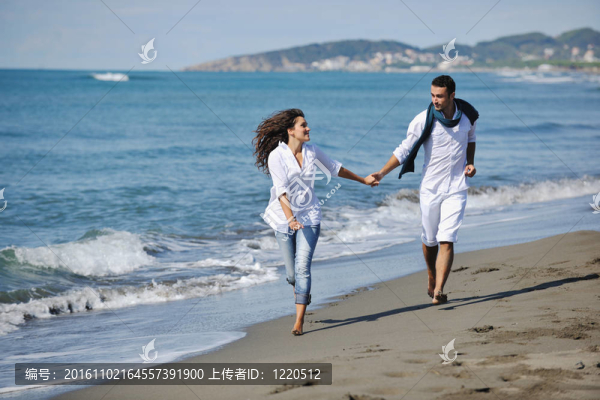 快樂的年輕夫婦在美麗的海灘上玩得開心